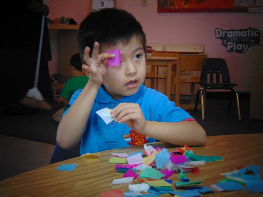 Young boy holding cut-out art paper.