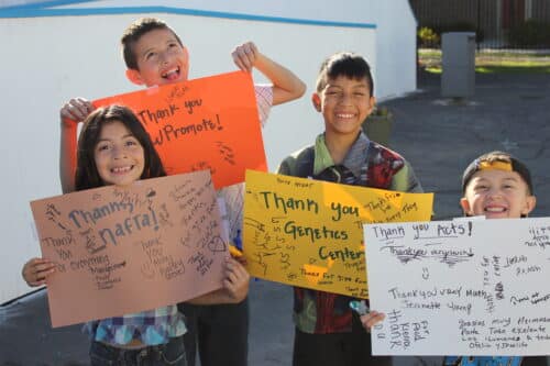 Four children holding handmade thank you signs