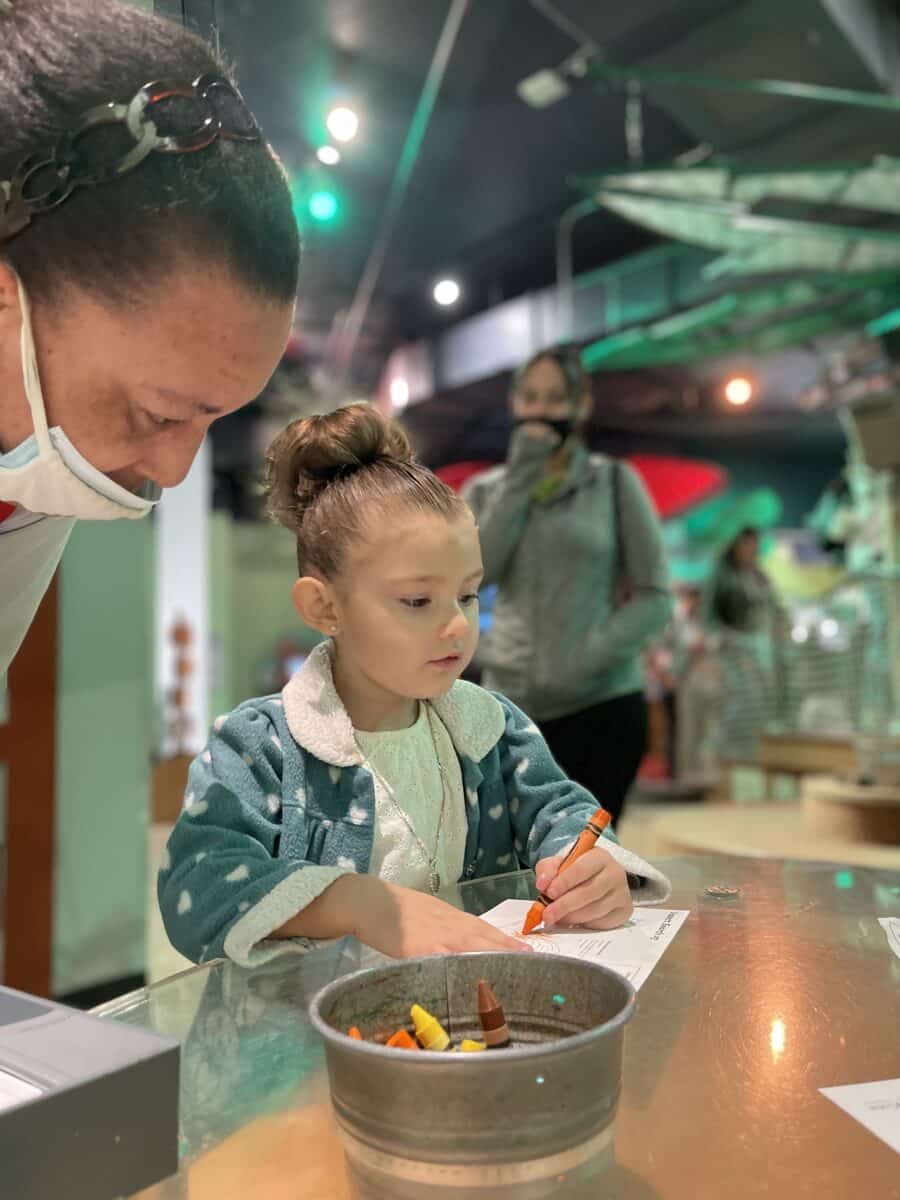 Young girl coloring with adult